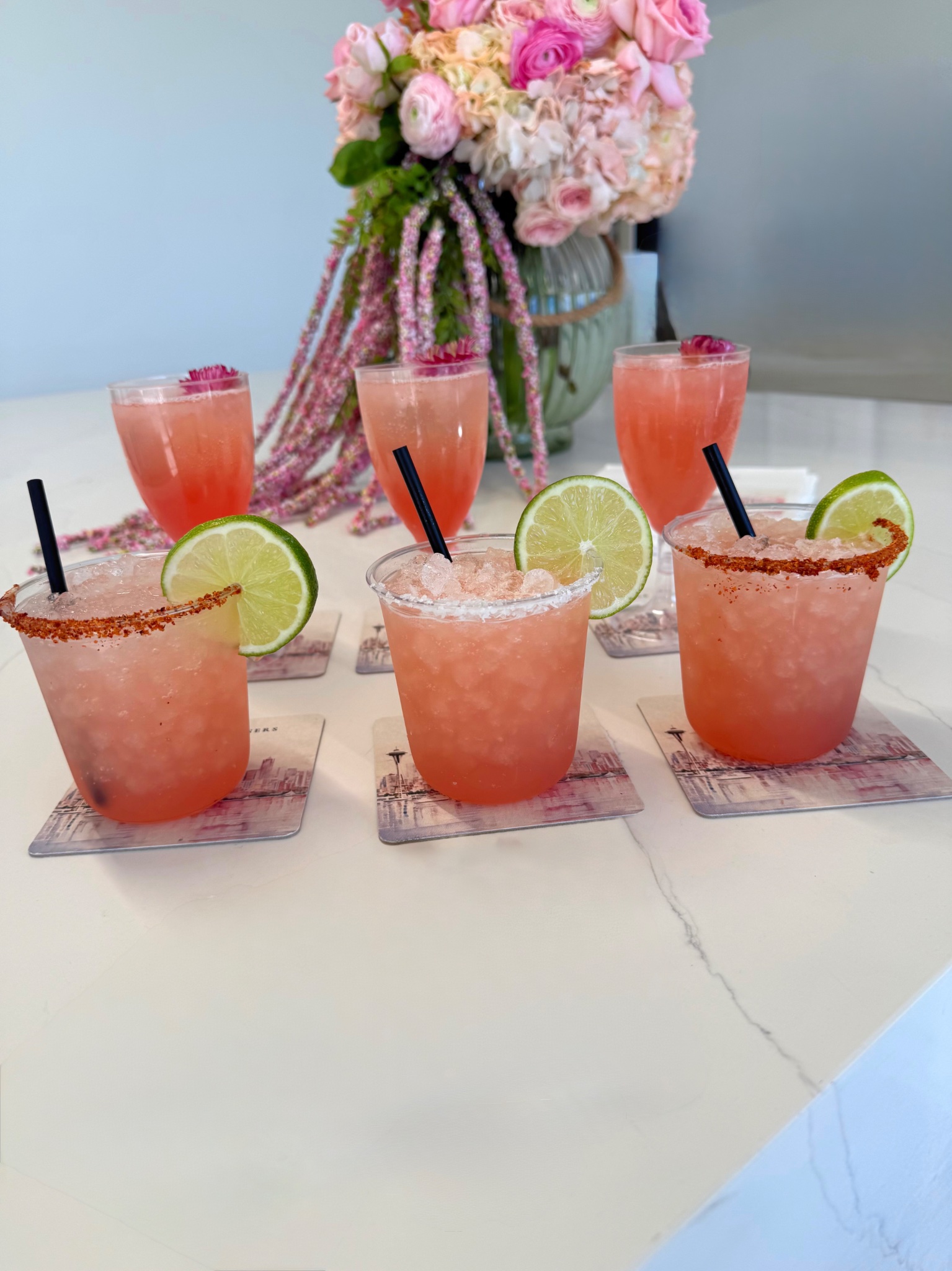 Pink margaritas with floral arrangement